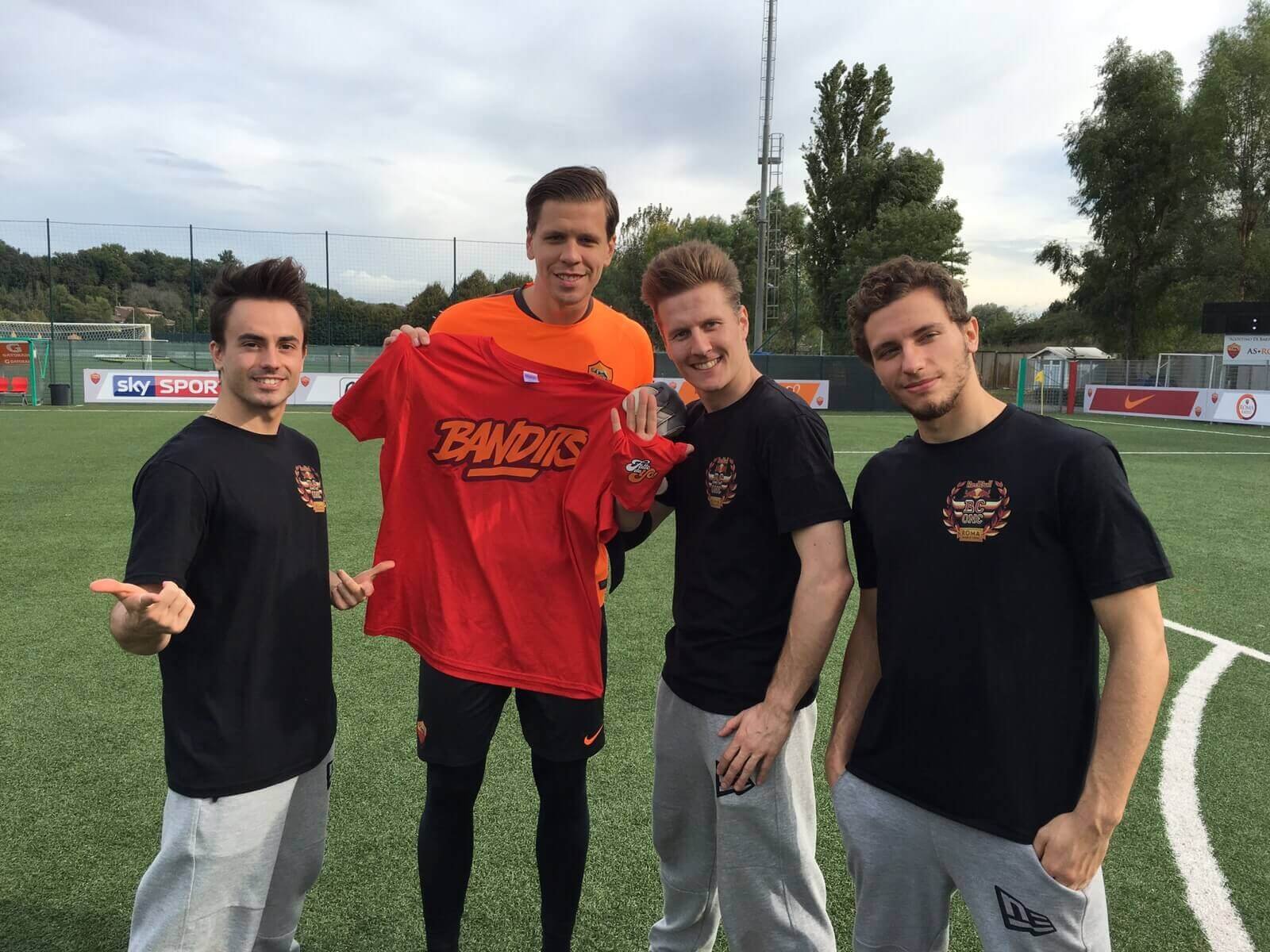 Quattro uomini con maglia sportiva in campo calcio.