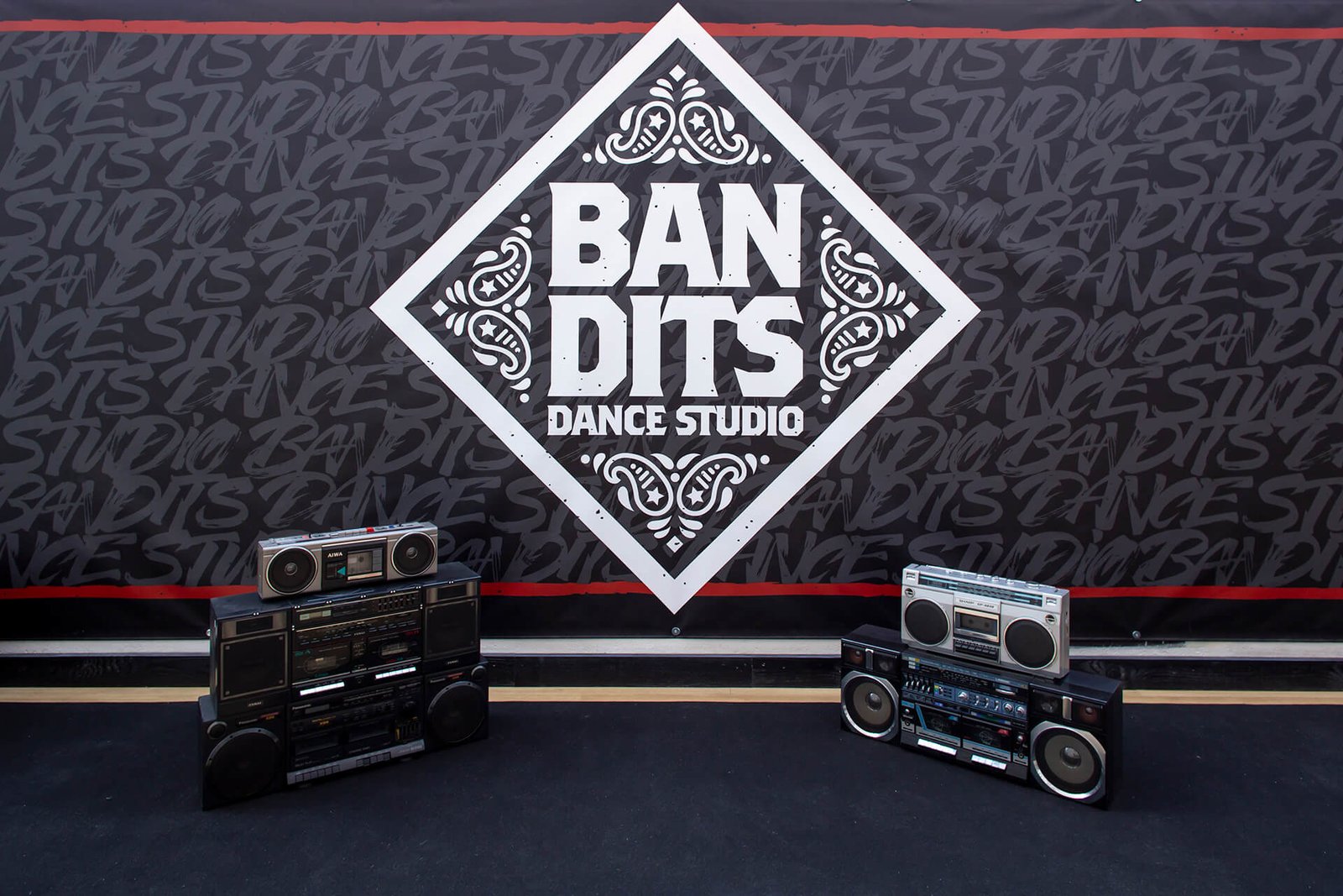 Parete con logo "BANDITS Dance Studio" e boombox vintage.
