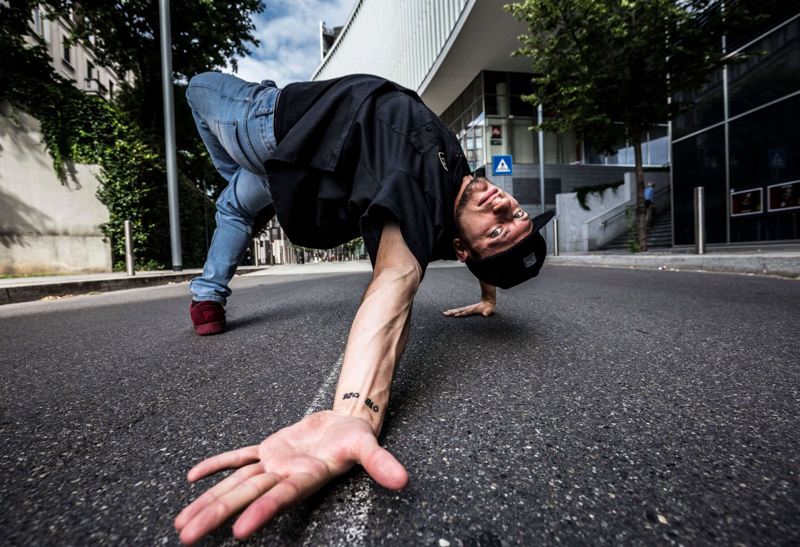 Acrobata urbano esegue breakdance in strada.