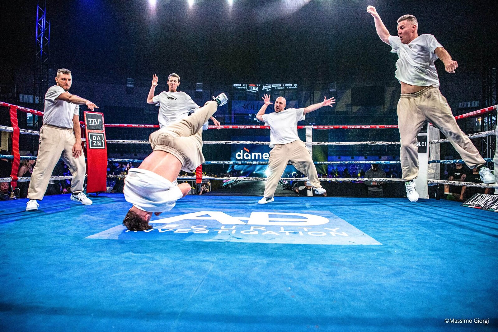 Uomini in performance di breakdance sul ring di boxe.