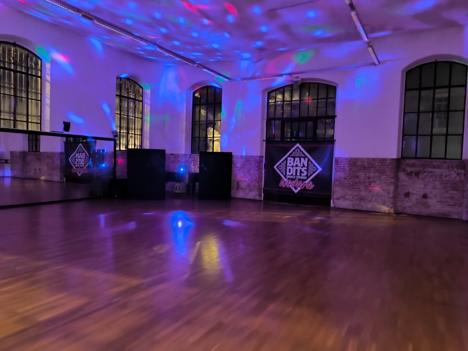 Sala Bandits Dance Studio con luci colorate durante sessione di breakdance