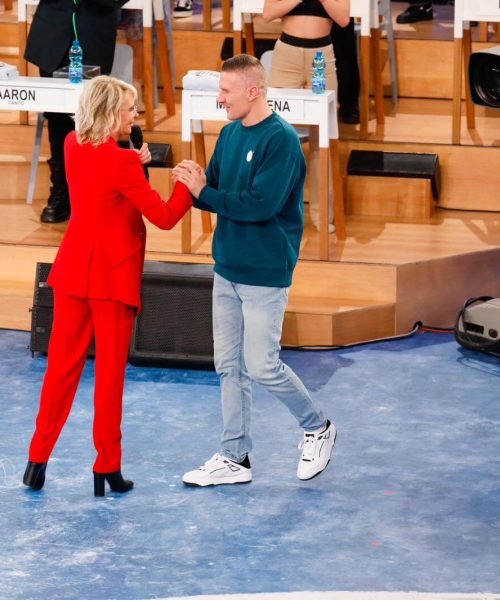 Roman Froz ad Amici di Maria De Filippi Due persone si salutano in uno studio televisivo.